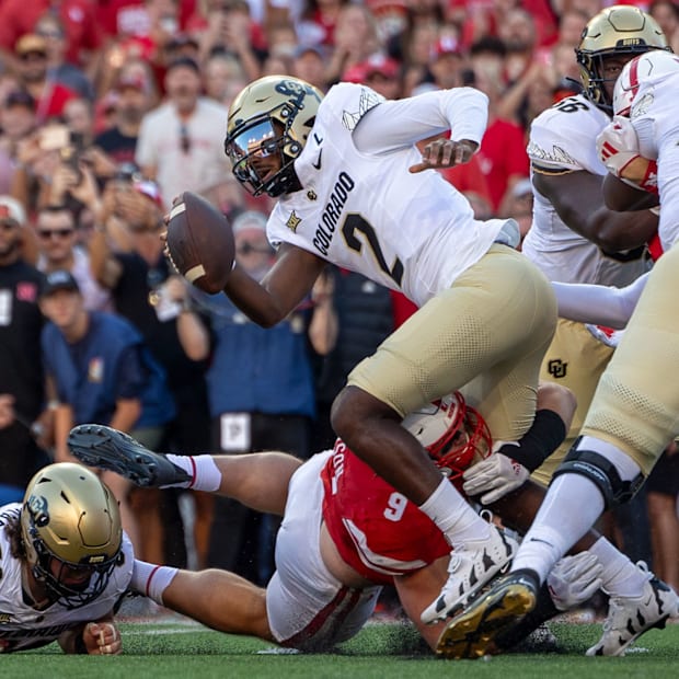 Colorado quarterback Shedeur Sanders tries to no avail to escape the grasp of Nebraska defensive lineman Ty Robinson.