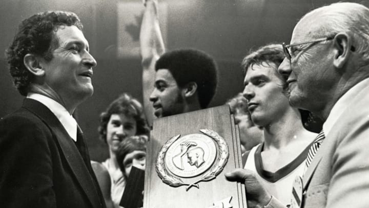 Mar 28, 1977; Atlanta,GA, USA; FILE PHOTO; Marquette Golden Eagles head coach Al McGuire is presented the NCAA Championship trophy after defeating North Carolina 67-59. McGuire retired after this Championship game. Mandatory Credit: Malcolm Emmons- Imagn Images