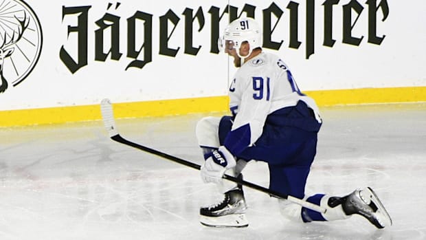 Hockey player in white uniform celebrates a goal