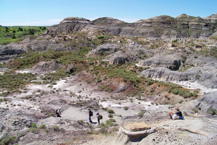 Aerial photo of the Hell Creek badlands with paleontologists in the foreground