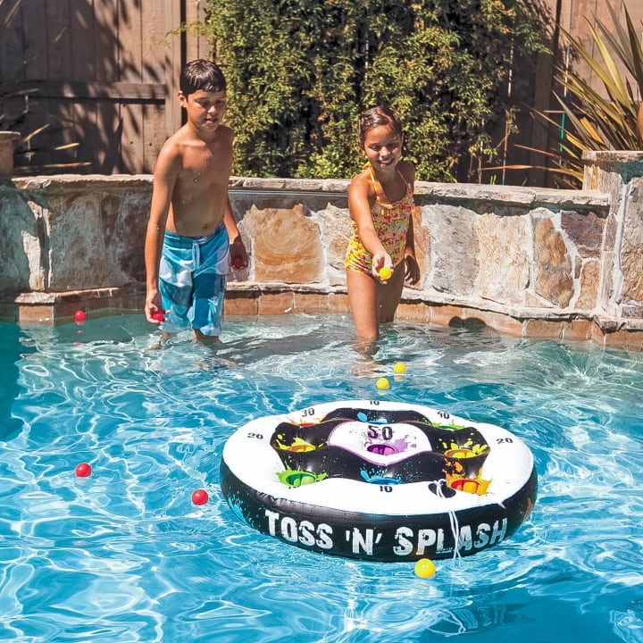 Two kids playing with a Toss 'N' Splash in a pool