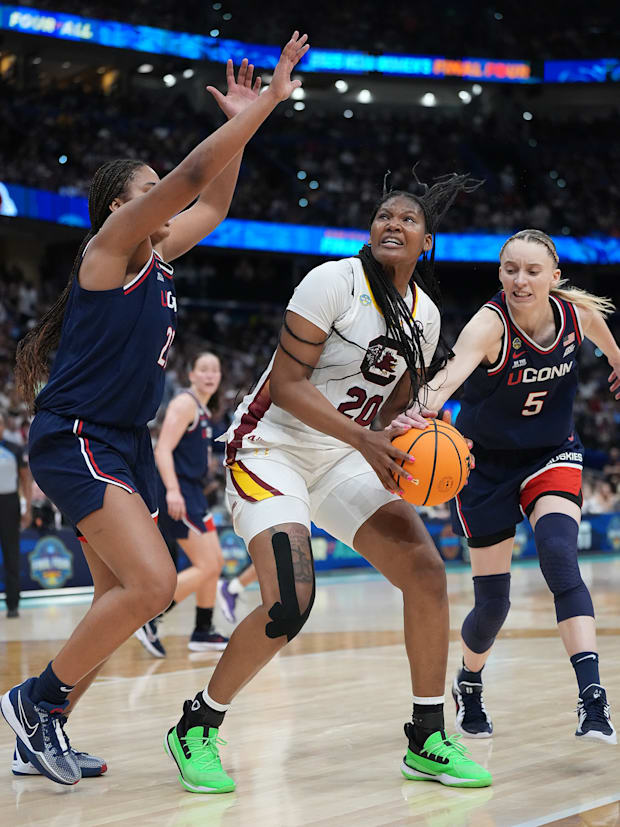 South Carolina forward Sania Feagin tries to make a shot while fending off UConn's Paige Bueckers and Sarah Strong. 