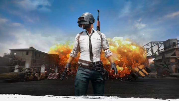 A man standing in a white shirt and black tie with jeans. He has a welding mask over his face and a pistol in his hands.