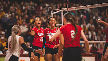 Nebraska volleyball players celebrate a point at Minnesota.