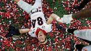 Georgia Bulldogs wide receiver Ladd McConkey (84) lays in confetti after winning the College Football Playoff National Championship on Monday, Jan. 10, 2022, at Lucas Oil Stadium in Indianapolis. The Georgia Bulldogs defeated the Alabama Crimson Tide in the College Football playoff National Championship, 33-18, earning the title for the first time in 41 years. They clinched the win with several touchdowns in the fourth quarter. A 40-yard touchdown by Adonai Mitchell (5), pictured second, gave