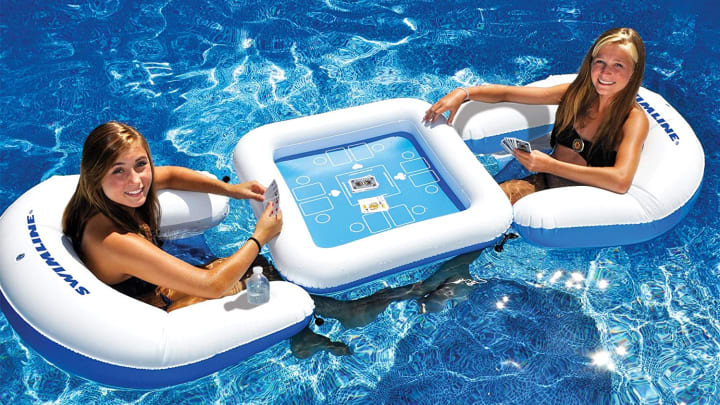People sitting in a pool with a Game Station Set and Waterproof Playing Cards