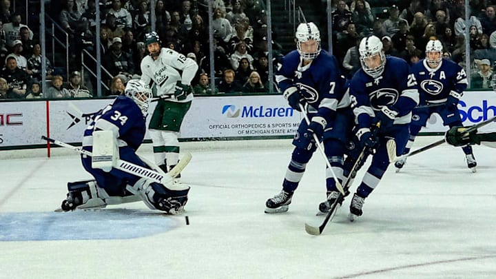 Michigan State's Porter Martone (22) shoots the puck past defenders and Penn State goaltender  Josh Fleming (34) late in the first period at Munn Ice Arena Saturday, Nov. 8, 2025.