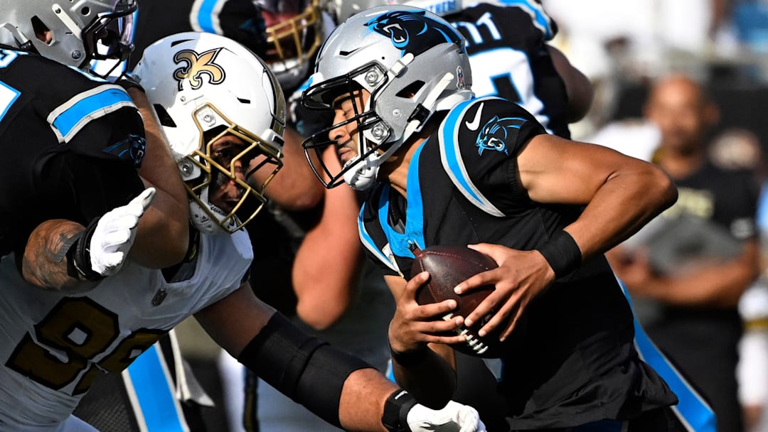 Nov 9, 2025; Charlotte, North Carolina, USA; Carolina Panthers quarterback Bryce Young (9) scrambles as New Orleans Saints defensive end Chase Young (99) pressures in the third quarter at Bank of America Stadium. 