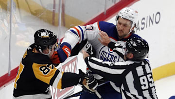 Mar 10, 2024; Pittsburgh, Pennsylvania, USA;  Pittsburgh Penguins center Sidney Crosby (87) and Edmonton Oilers defenseman Vincent Desharnais (73) are separated by linesman Jonny Murray (95) during the third period at PPG Paints Arena. The Oilers won 4-0. Mandatory Credit: Charles LeClaire-Imagn Images