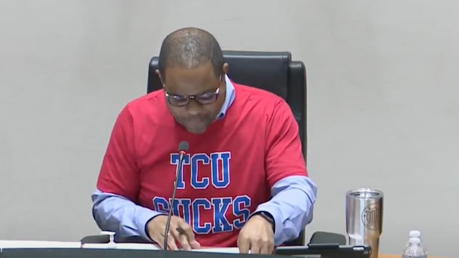 Dallas mayor Eric Johnson wearing a 'TCU Sucks' shirt at a city council meeting.  | Screenshot via NBC DFW on YouTube