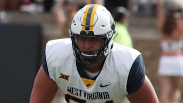 Oct 22, 2022; Lubbock, Texas, USA;  West Virginia Mountaineers offensive tackle Wyatt Milum (65) prepares to block against the Texas Tech Red Raiders in the second half at Jones AT&T Stadium and Cody Campbell Field. Mandatory Credit: Michael C. Johnson-Imagn Images