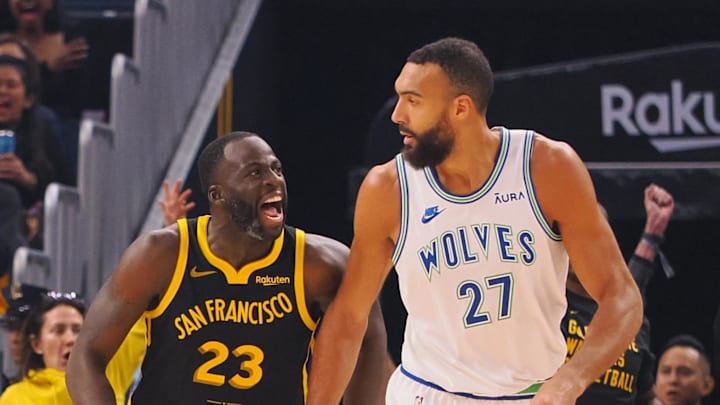 Nov 12, 2023; San Francisco, California, USA; Golden State Warriors forward Draymond Green (23) celebrates behind Minnesota Timberwolves center Rudy Gobert (27) after scoring a three point basket during the first quarter at Chase Center.