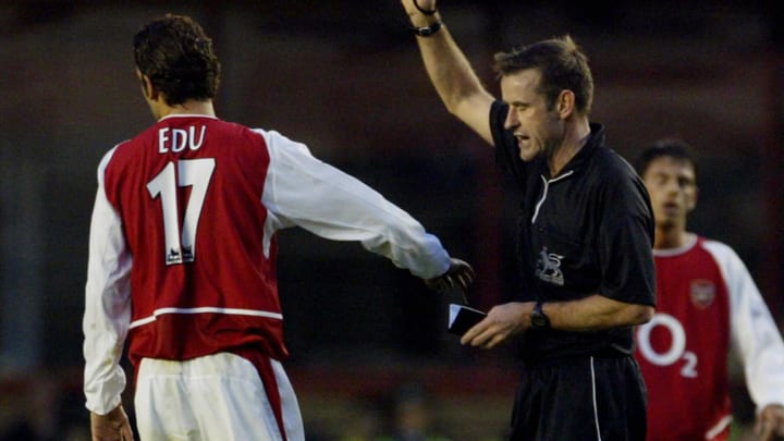 Arsenal's Edu (L) receives a yellow card