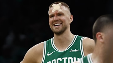 Apr 23, 2025; Boston, Massachusetts, USA; Boston Celtics center Kristaps Porzingis (8) smiles upon returning to the court to shoot fouls shots after being cut by an elbow during the second half of game two of the first round of the 2024 NBA Playoffs against the Orlando Magic at TD Garden. Mandatory Credit: Winslow Townson-Imagn Images