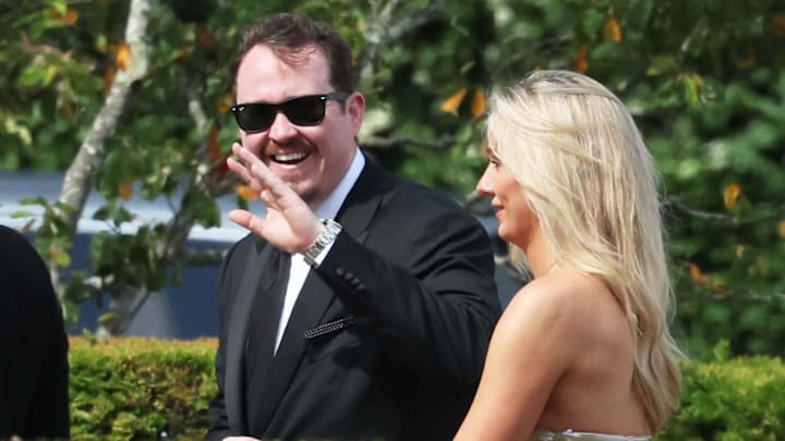 Comedian Shane Gillis waves to the spectators at the Olivia Culpo and Christian McCaffrey wedding with girlfriend Grace Brassel.