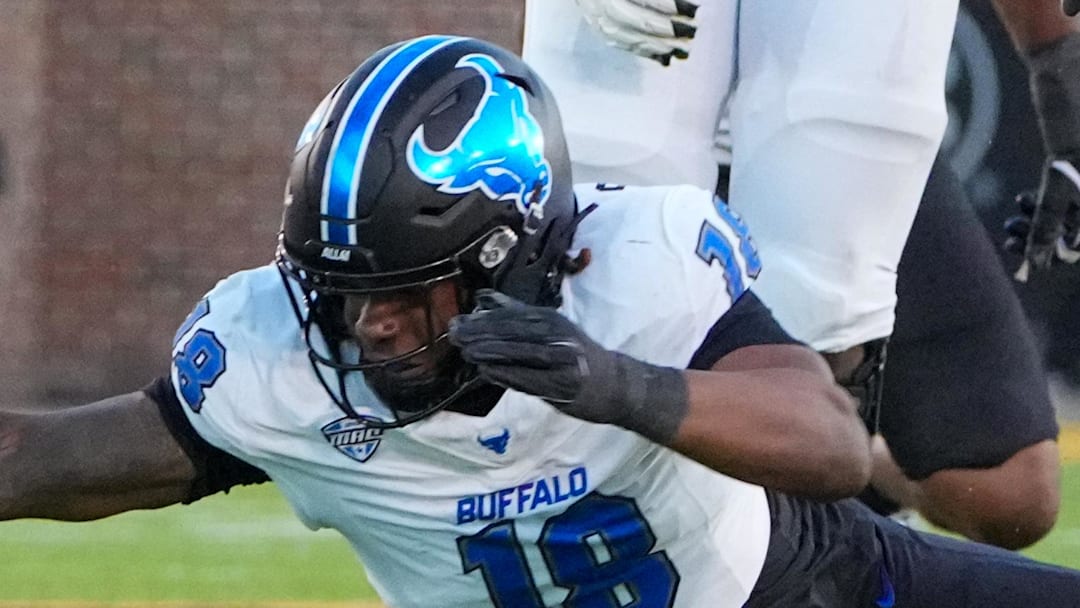 Sep 7, 2024; Columbia, Missouri, USA; Missouri Tigers quarterback Brady Cook (12) leaps over Buffalo Bulls linebacker Dion Crawford (18) and runs in for a touchdown during the first half at Faurot Field at Memorial Stadium.