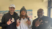Deshonne Redeaux meets with UW coaches Jimmie Dougherty and Scottie Graham. 