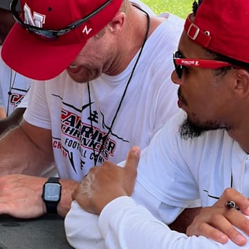 Adam Carriker signs autographs at his youth football camp alongside other Husker legends.
