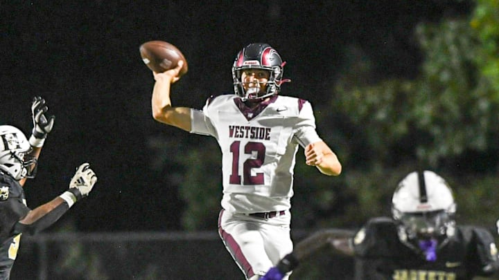 Westside High senior quarterback Cutter Woods (12) leaps to throw a pass by TL Hanna High players during the first quarter at T.L. Hanna High in Anderson, S.C. Friday, September 6, 2024.