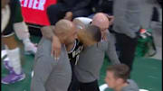 Bucks staffers help Damian Lillard off the court after an injury against the Pacers.