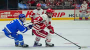 Wisconsin defenseman Zach Schulz (5) and Air Force forward Brian Adams (7) seen Thursday, Dec. 28, 2023, in the Kwik Trip Holiday Face-Off at Fiserv Forum in Milwaukee. Ebony Cox / Milwaukee Journal Sentinel