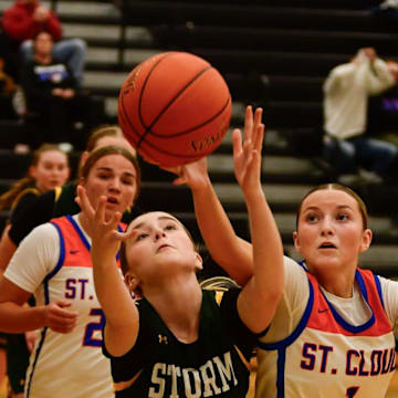 Sauk Rapids girls basketball sophomore Brooklyn Widmer and St. Cloud Crush junior Weslie Schuck go after a loose ball during a game Dec. 6, 2024 at Sauk Rapids High School. The Storm lost 70-51.
