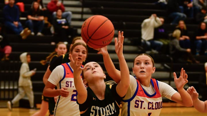 Sauk Rapids girls basketball sophomore Brooklyn Widmer and St. Cloud Crush junior Weslie Schuck go after a loose ball during a game Dec. 6, 2024 at Sauk Rapids High School. The Storm lost 70-51.