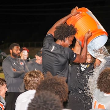 Oviedo High football players give head coach Greg Odierno a Gatorade bath after beating Evans, 29-28, in double overtime to win the Class 6A, District 4 championship. It was the Lions' fourth consecutive district title.