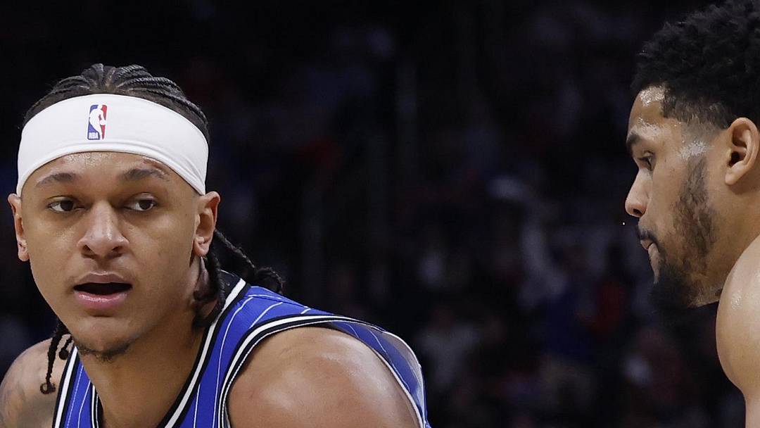 Orlando Magic forward Paolo Banchero dribbles defended by Detroit Pistons forward Tobias Harris.