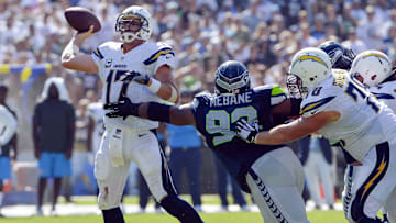 Sep 14, 2014; San Diego, CA, USA; San Diego Chargers quarterback Philip Rivers (17) throws a third quarter touchdown to tight end Antonio Gates (not pictured) while eluding the grasp of Seattle Seahawks defensive tackle Brandon Mebane (92) at Qualcomm Stadium. 