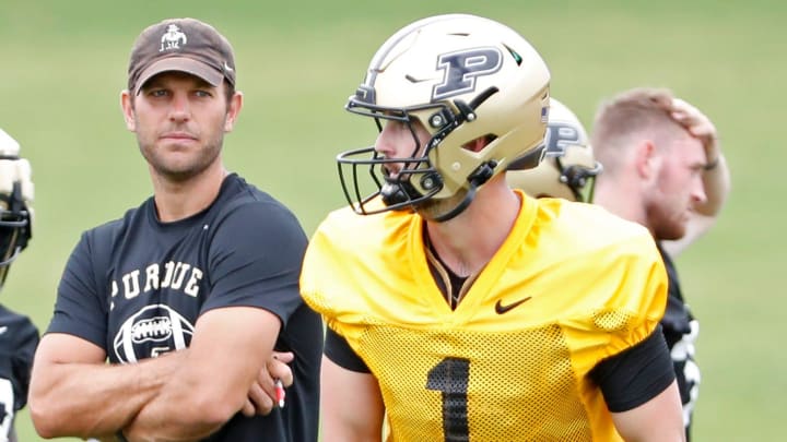 Purdue Boilermakers offensive coordinator Graham Harrell watches as quarterback Hudson Card (1) prepares to throw.