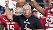 Sep 7, 2024; Charlotte, North Carolina, USA; North Carolina State Wolfpack head coach Dave Doeren leads his team onto the field against the Tennessee Volunteers during the first quarter at the Dukes Mayo Classic at Bank of America Stadium. Mandatory Credit: Jim Dedmon-Imagn Images