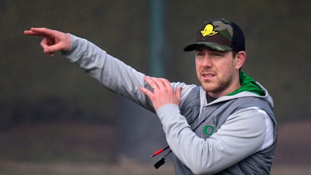 New Oregon offensive coordinator and quarterbacks coach Will Stein leads a drill on the first practice of spring for Oregon f