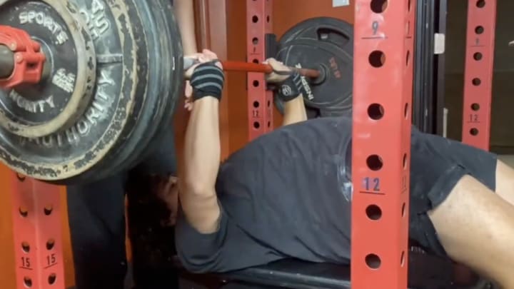 Marcello Vitti bench-pressing a significant amount of weight. 