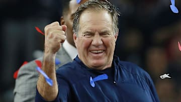 Former New England Patriots head coach Bill Belichick celebrating on the field following a victory. 