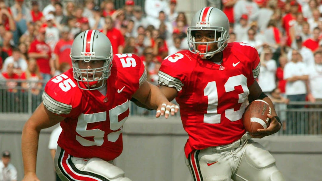 (OSUIU LAURON 28SEP02) Ohio State Buckeyes Maurice Clarett (cq) 13, uses teammate Nick Mangold (cq) 55, to clear the way and open up a hole in the first quarter against the Indiana Hoosiers at the Ohio Stadium, September 28, 2002. (Dispatch photo by Neal C. Lauron)Ncl Osuiu 