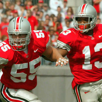 (OSUIU LAURON 28SEP02) Ohio State Buckeyes Maurice Clarett (cq) 13, uses teammate Nick Mangold (cq) 55, to clear the way and open up a hole in the first quarter against the Indiana Hoosiers at the Ohio Stadium, September 28, 2002. (Dispatch photo by Neal C. Lauron)Ncl Osuiu 