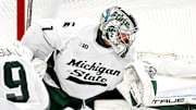 Michigan State's Trey Augustine, center, stops the puck after a Michigan shot during the first period on Friday, Dec. 5, 2025, at Munn Ice Arena in East Lansing.