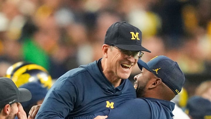 Michigan offensive coordinator Sherrone Moore picks up head coach Jim Harbaugh after they won the College Football Playoff national championship game against Washington at NRG Stadium in Houston, Texas on Monday, January 8, 2024.