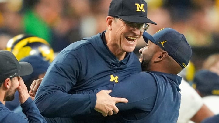 Michigan offensive coordinator Sherrone Moore picks up head coach Jim Harbaugh after they won the College Football Playoff national championship game against Washington at NRG Stadium in Houston, Texas on Monday, Jan. 8, 2024.