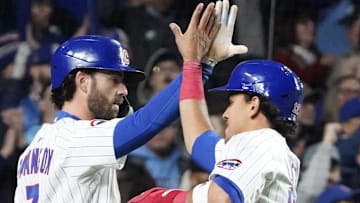 Chicago Cubs shortstop Dansby Swanson (7) greets third baseman Nicky Lopez (12) after they scored against the San Francisco Giants.