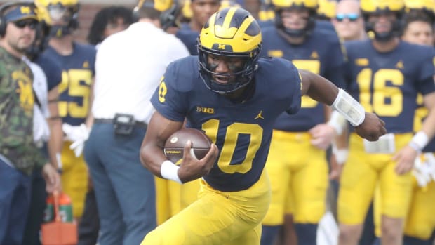 Michigan Wolverines quarterback Alex Orji runs with the ball during a college football game in the Big Ten.