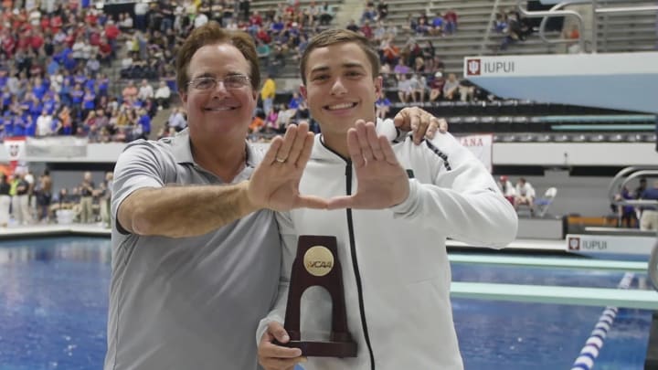 Randy Albeman holding up the Miami U with diver at the NCAA Tournament