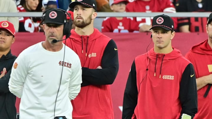 San Francisco 49ers quarterback Brock Purdy and head coach Kyle Shanahan look on from the sideline.