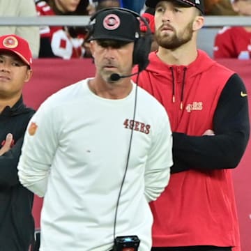 Jan 5, 2025; Glendale, Arizona, USA;  San Francisco 49ers quarterback Brock Purdy (right) and head coach Kyle Shanahan (left) look on the in second half against the Arizona Cardinals at State Farm Stadium. Mandatory Credit: Matt Kartozian-Imagn Images