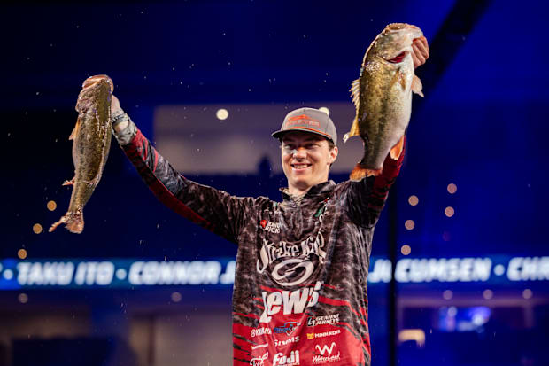 Easton Fothergill holding up two big bass on the Day 2 weigh-in stage