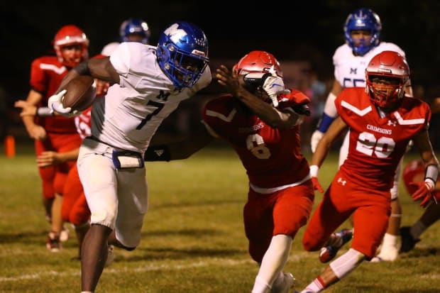 Decatur MacArthur's Myson Johnson-Cook stiff-arms a Jacksonville defender during an Illinois conference game in Sept. 2023.