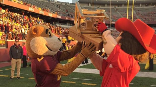 Mascots for the Minnesota Golden Gophers and Nebraska Cornhuskers hold the $5 Bits of Broken Chair Trophy.