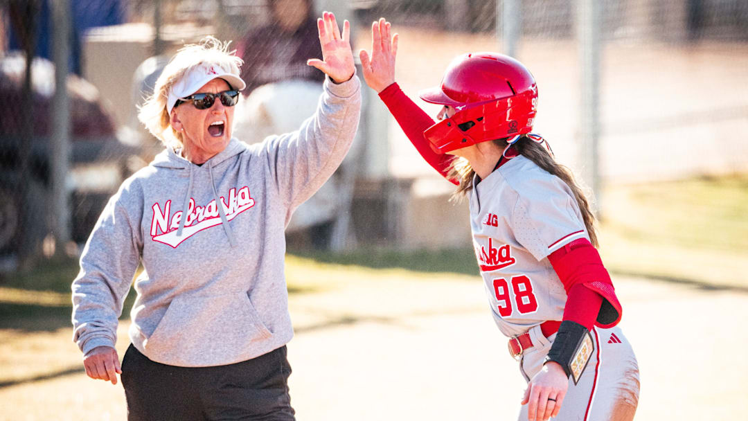 Nebraska softball head coach Rhonda Revelle high-fives Jordy Bahl at third base.