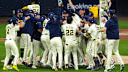 The Brewers celebrate on the field after winning Game 5 of the NLDS against the Cubs at American Family Field.